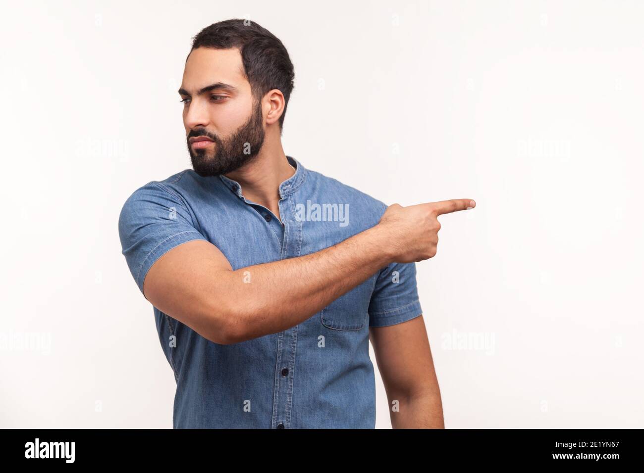 Verärgert wütend Mann mit Bart in blauem Hemd zeigt Finger weg mit ärgerlichen Ausdruck, verwirrt mit Konflikt, tritt aus. Studio-Zimmer im Innenbereich Stockfoto