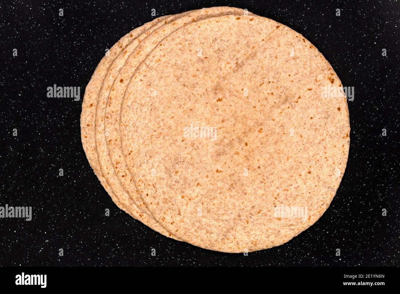 Makro von Weizenmehl Tortilla Pfannkuchen isoliert auf schwarz, Hintergrund und Textur. Stockfoto