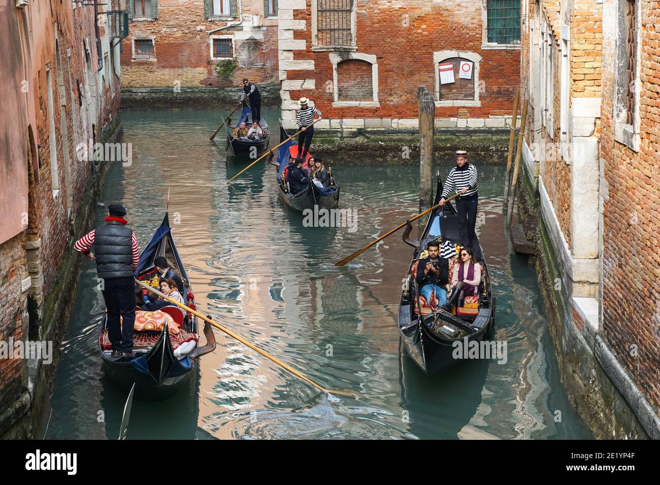 Gondoliere auf traditionellen venezianischen Gondeln mit Touristen auf dem rio della Fava Kanal in Venedig, Italien Stockfoto