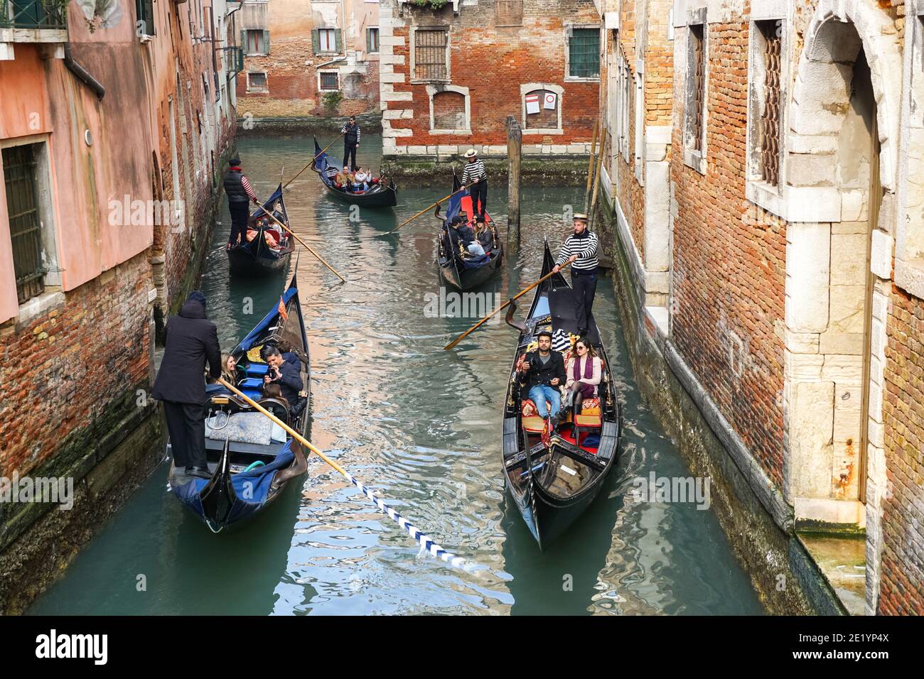 Gondoliere auf traditionellen venezianischen Gondeln mit Touristen auf dem rio della Fava Kanal in Venedig, Italien Stockfoto