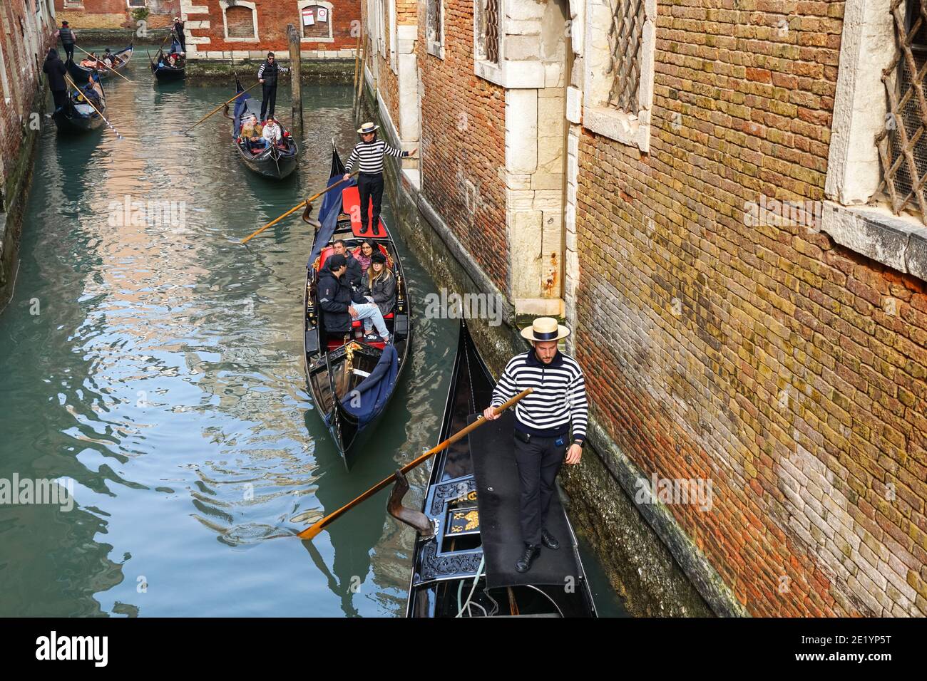 Gondoliere auf traditionellen venezianischen Gondeln mit Touristen auf dem rio della Fava Kanal in Venedig, Italien Stockfoto