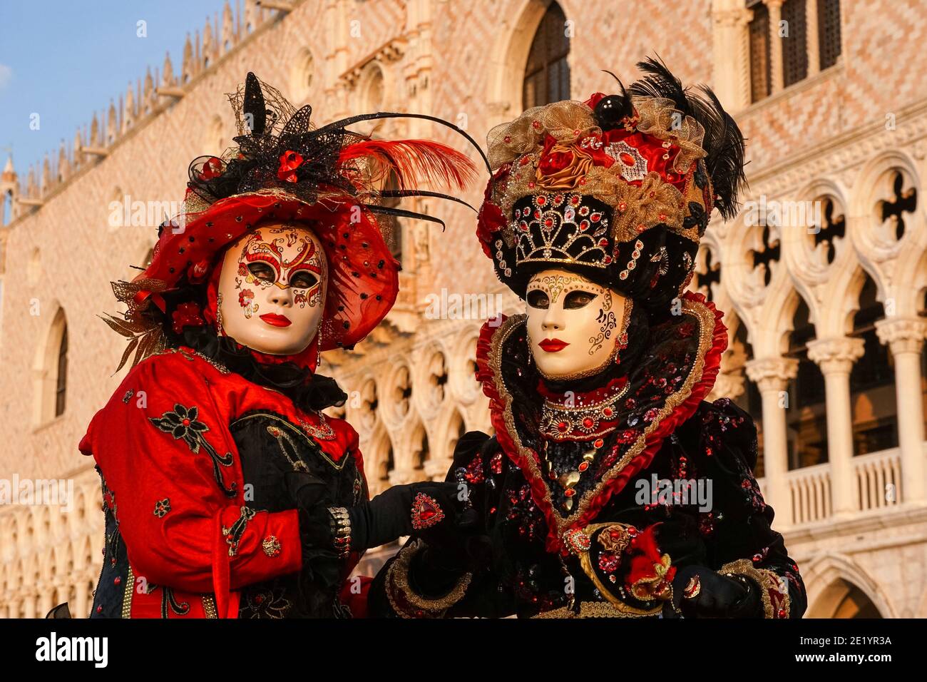 Zwei Frauen in traditionell dekorierten Kostümen und Masken vor dem Dogenpalast während des Karnevals in Venedig, Italien Stockfoto