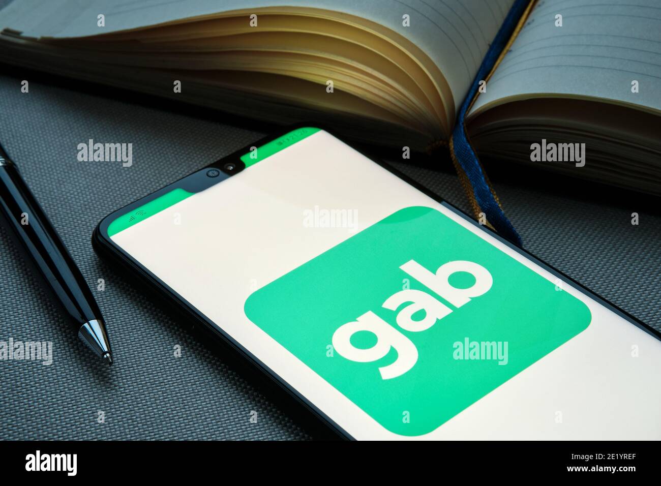 Stafford, Vereinigtes Königreich - Januar 10 2021: GAB Social Media auf der Smarthpne neben Tagebuch und Stift platziert gesehen. Gab App ist ein Mikro-Blogging Social netwo Stockfoto