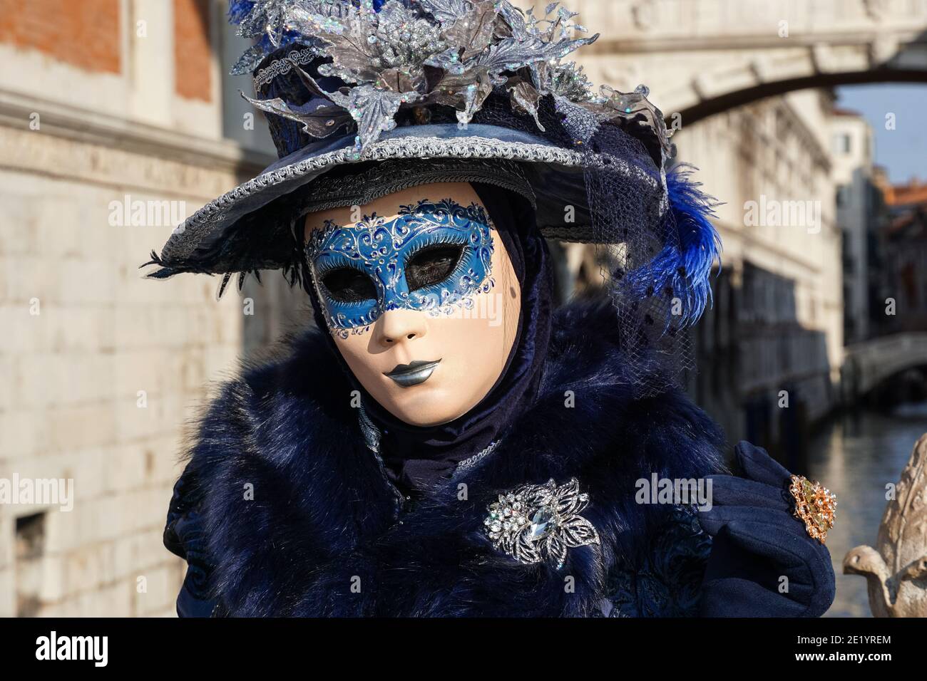 Frau in traditionell dekoriertem Kostüm mit Hut und bemalter Maske während des Karnevals in Venedig, Italien Stockfoto