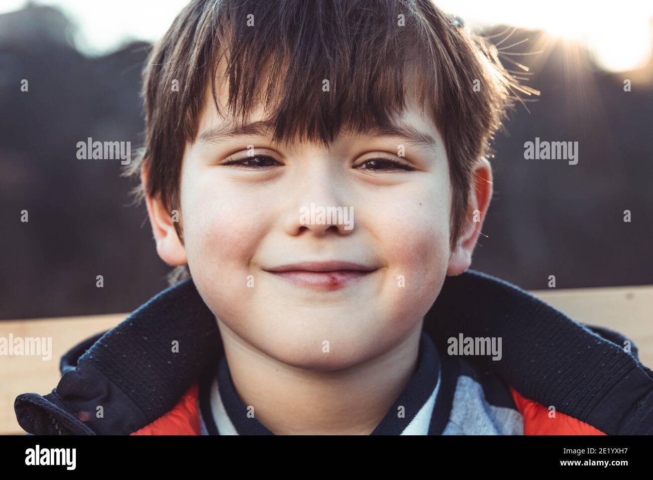 Porträt eines niedlichen, kleinen Jungen mit Pony, lächelnd Stockfoto