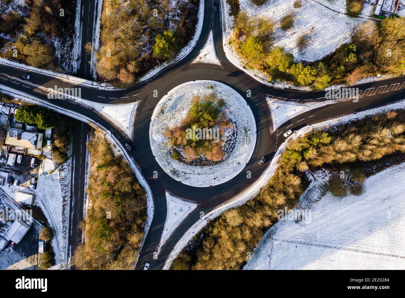 Luftaufnahme eines von Schnee umgebenen Verkehrskreisel und Bäume in einer walisischen Stadt Stockfoto