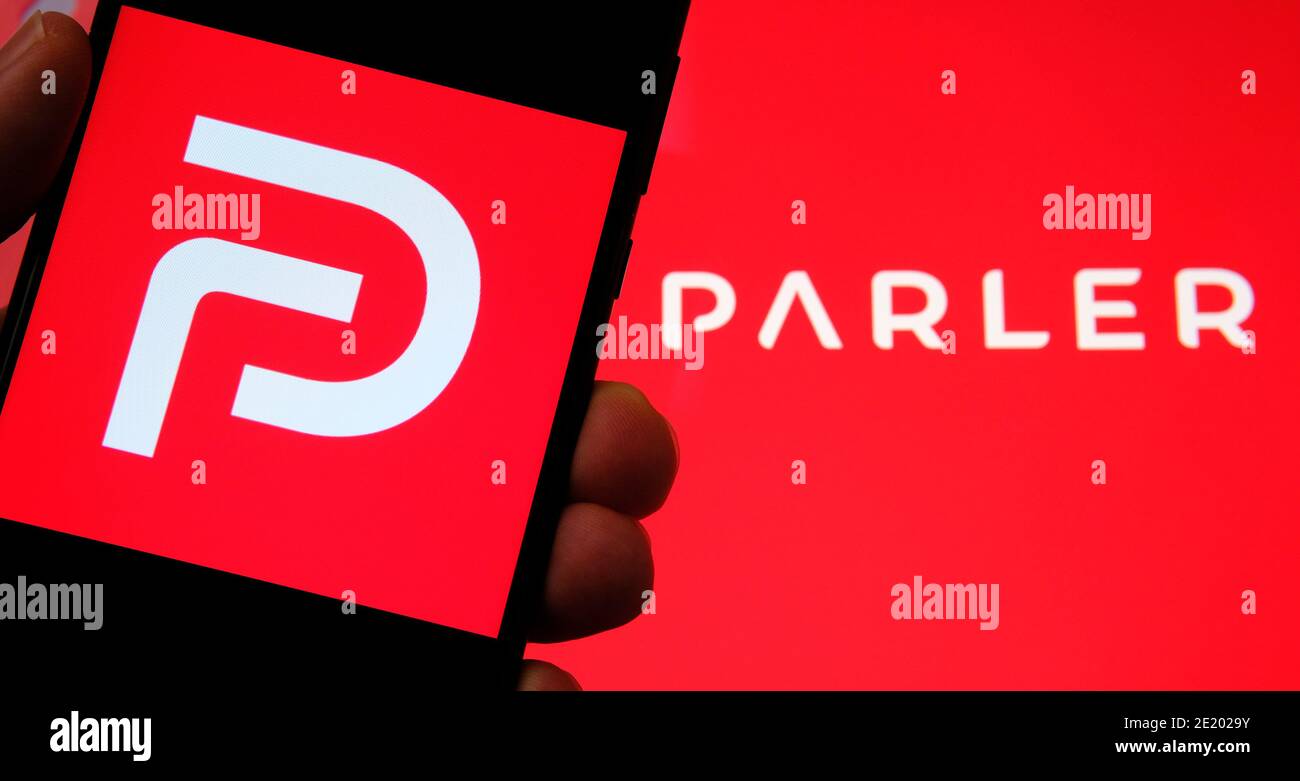 Parler App-Logo auf dem Bildschirm des Smartphones und auf dem verschwommenen Hintergrund zu sehen. Parler ist eine neue Social-Media-Plattform zur Förderung der Meinungsfreiheit. Stockfoto