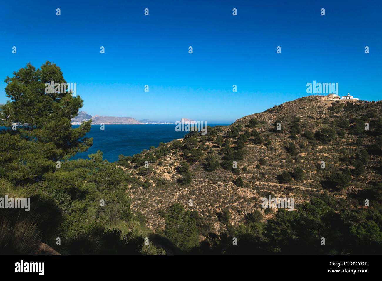 Sonniger Panoramablick auf den Naturpark 'Serra Gelada' mit Leuchtturm und dem Felsen 'Ifach' von Calpe im Hintergrund, Albir, Costa Blanca, Spanien Stockfoto