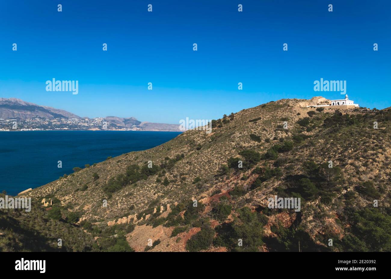 Naturpark 'Serry Gelada' mit Blick auf Leuchtturm und Ruine der Ockermine entlang der Küste von Albir, Costa Blanca, Spanien Stockfoto