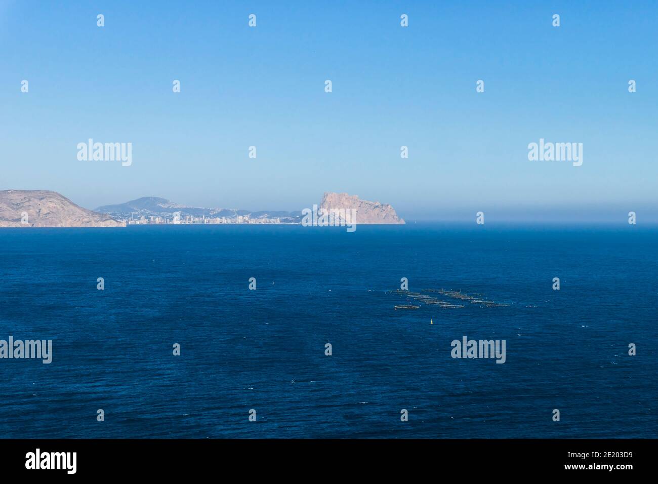 Mittelmeer mit Fischfarm und Blick auf die Bergkette und den Felsen 'Ifach' von Calpe, Albir, Costa Blanca, Spanien Stockfoto