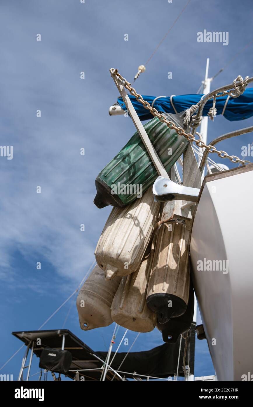 Schmutzige, gut benutzte Bootsfender hängen in einem Bündel am Heck eines Segelbootes. Stockfoto