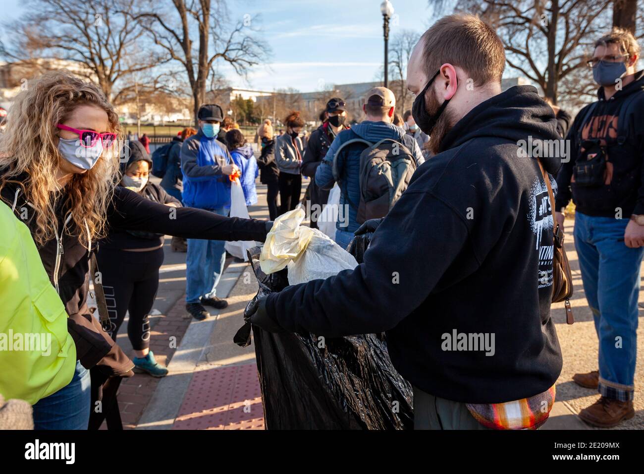 Washington, DC, USA, 10. Januar 2021. Im Bild: Eine Freiwillige Hände in ihren Müllbeutel während der Operation Clean Sweep. Die Veranstaltung war ein Versuch, Müll und Propaganda zu säubern, die von Faschisten und Trump-Anhängern nach dem Kapitolaufstand vom 6. Januar zurückgelassen wurden. Es wurde von Continue to Serve, einer antirassistischen Organisation von Militärveteranen, gehostet. Kredit: Allison C Bailey/Alamy Live Nachrichten Stockfoto