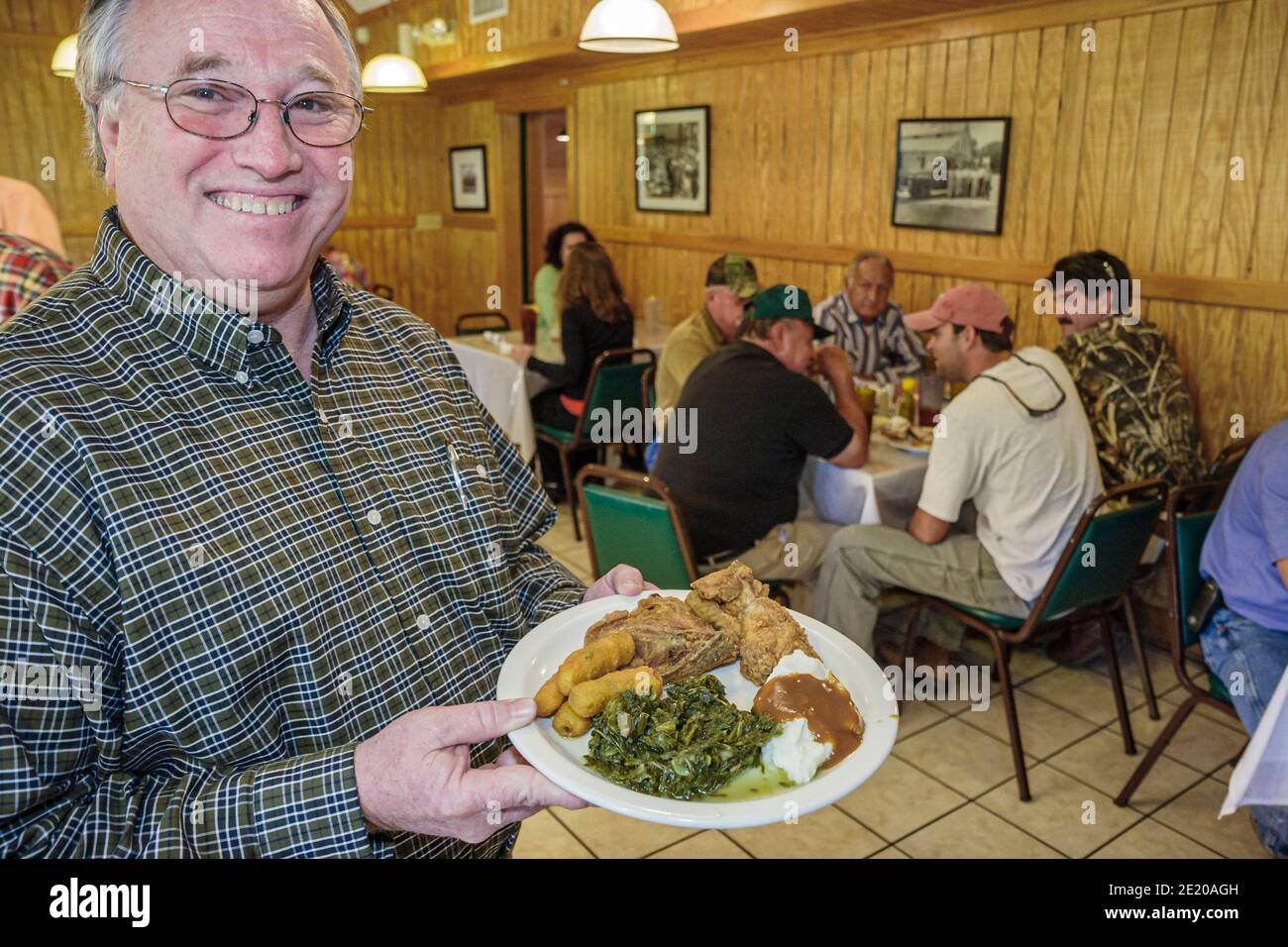 Alabama Monroeville Mockingbird Grill Restaurant Mann Diner, hält Lebensmittelplatte Mittagessen gebratenes Huhn, Rüben Grüns Kartoffelpüree, innen alles yo Stockfoto