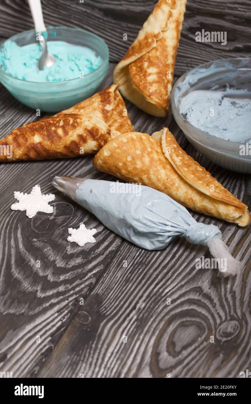 Zutaten für die Zubereitung von Dessert. Frischkäse in verschiedenen Farben, Waffelkegel und Schokolade. Stockfoto