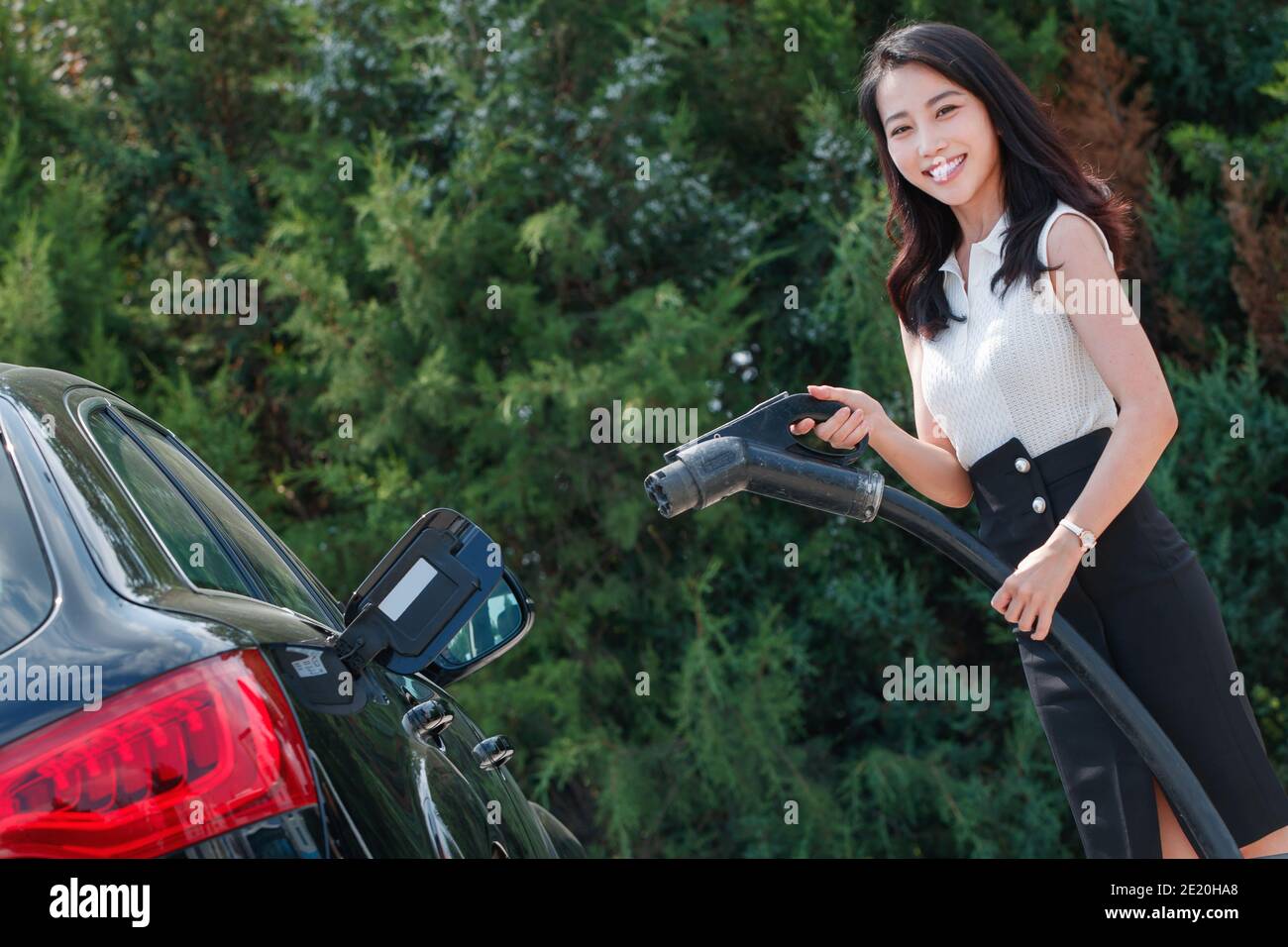 Mit einer Pistole für Autobatterie junge Frau Stockfoto