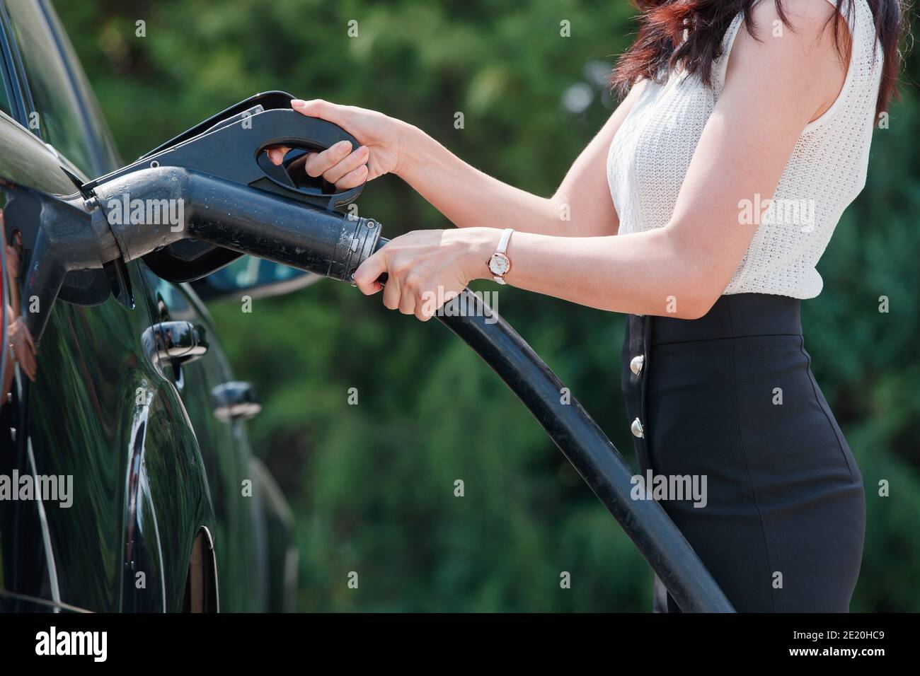 Junge Frauen zu Autobatterie Stockfoto