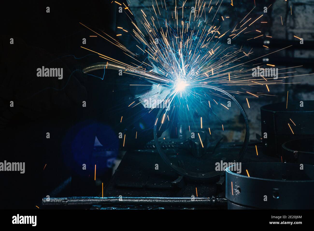 Funken und blaues Glühen des brennenden Gases des Schweißens in Die Dunkelheit Stockfoto