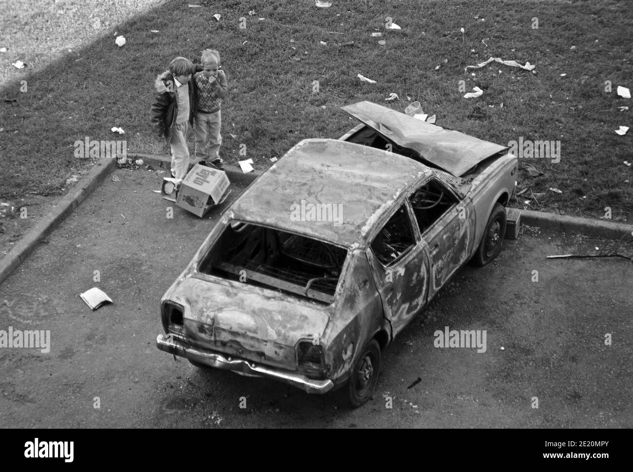 Kleine Kinder neben einem verbrannten Auto, September 1986, Ballymun, Dublin, Republik Irland Stockfoto