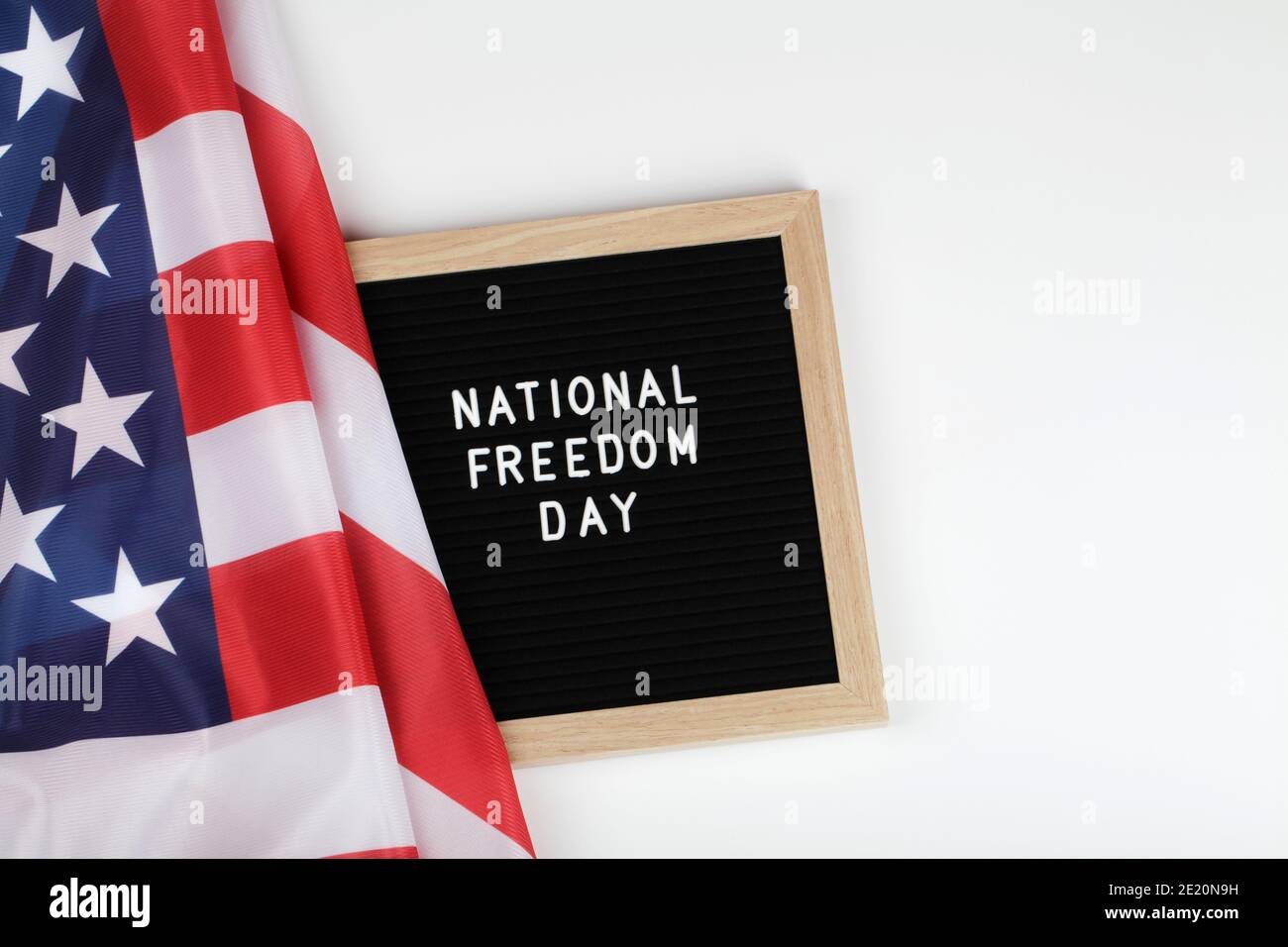 Schwarze Brieftafel mit Text National Freedom day und amerikanische Flagge auf weißem Hintergrund. Draufsicht flach Lay Copy Space Stockfoto