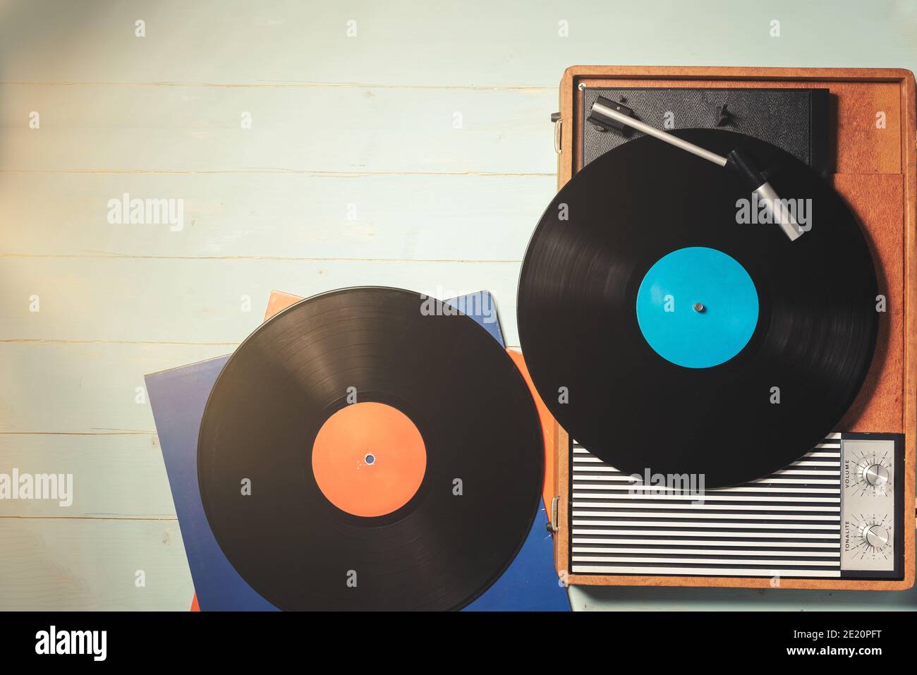 Vintage-Grammophon aus den 70er Jahren mit Vinyl-Schallplatten auf grünem Holztisch, Draufsicht und Kopierraum. Stockfoto