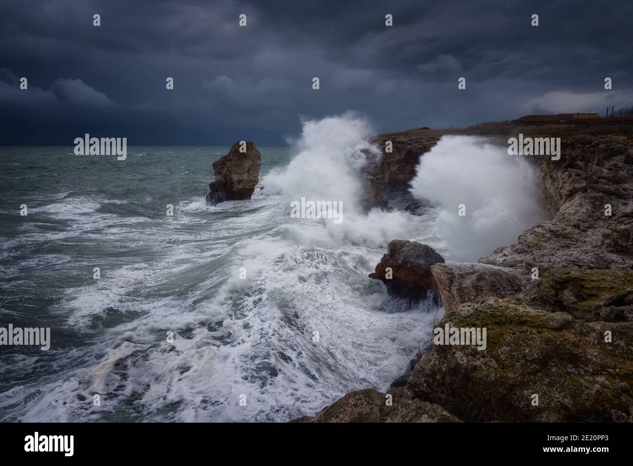 Dramatische Natur Hintergrund - große Wellen und dunklen Felsen in stürmischen Meer, stürmisches Wetter. Dramatische Szene. Kontrastierende Farben.schöne Naturlandschaft Stockfoto