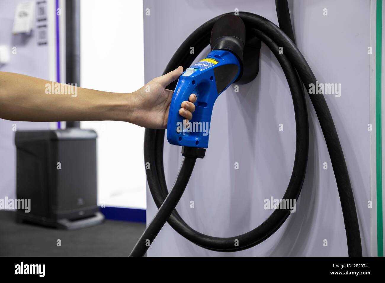 Auf Parkplatz mit Elektromobil Ladestation auf Stadtstraße Ladestation für Elektroautos. Nahaufnahme des Netzteils eingesteckt in einem Elektroauto wird ch Stockfoto