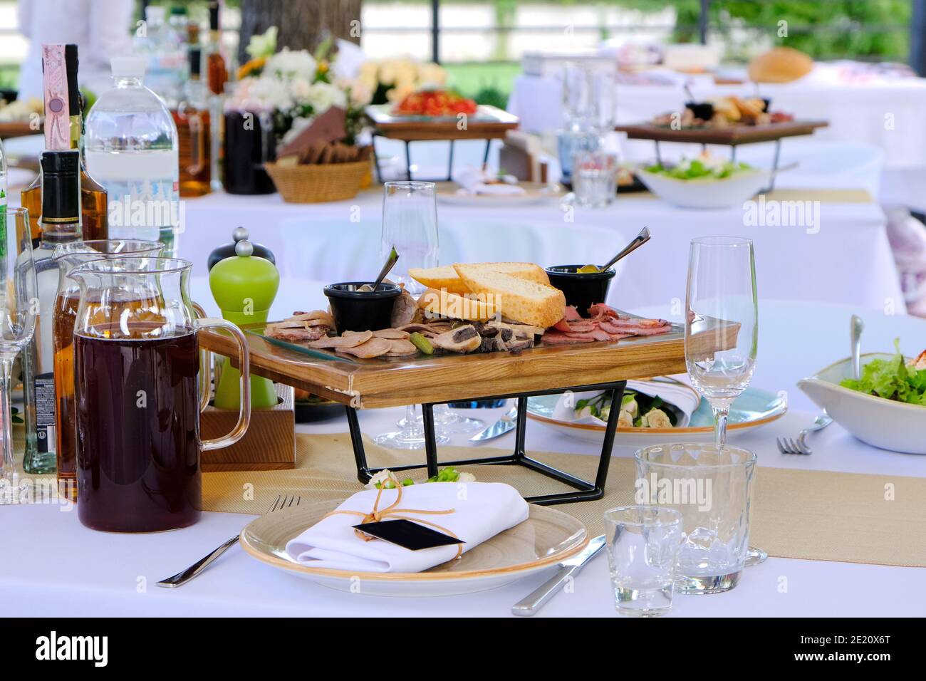 Köstliche Gerichte auf Holztabletts und Getränke auf einem Banketttisch in einem Luxusrestaurant. Stockfoto