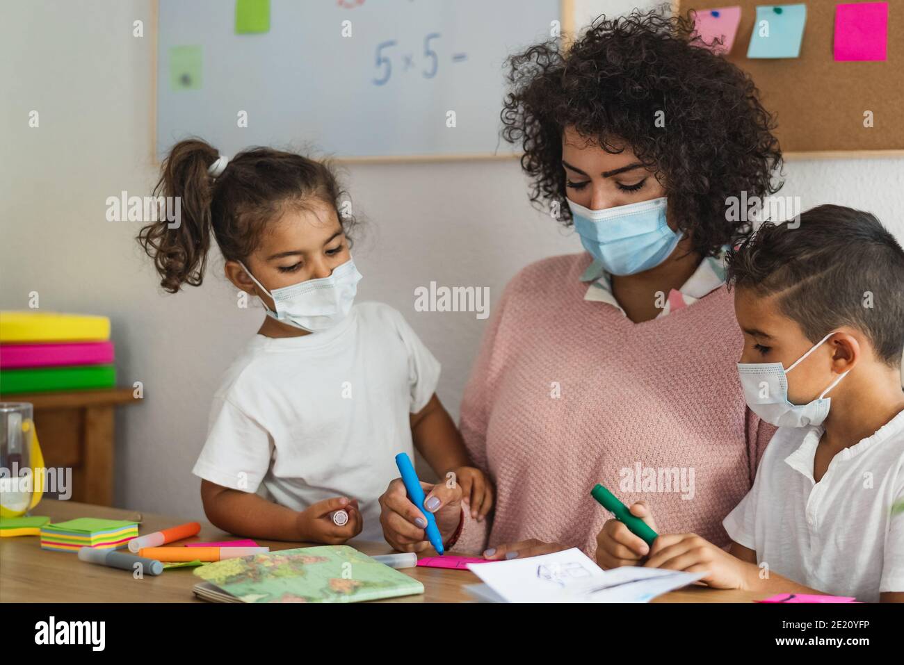 Lehrer mit Kindern tragen Gesichtsmaske in der Vorschule Klassenzimmer während corona Virus Pandemie - Gesundheits- und Bildungskonzept Stockfoto