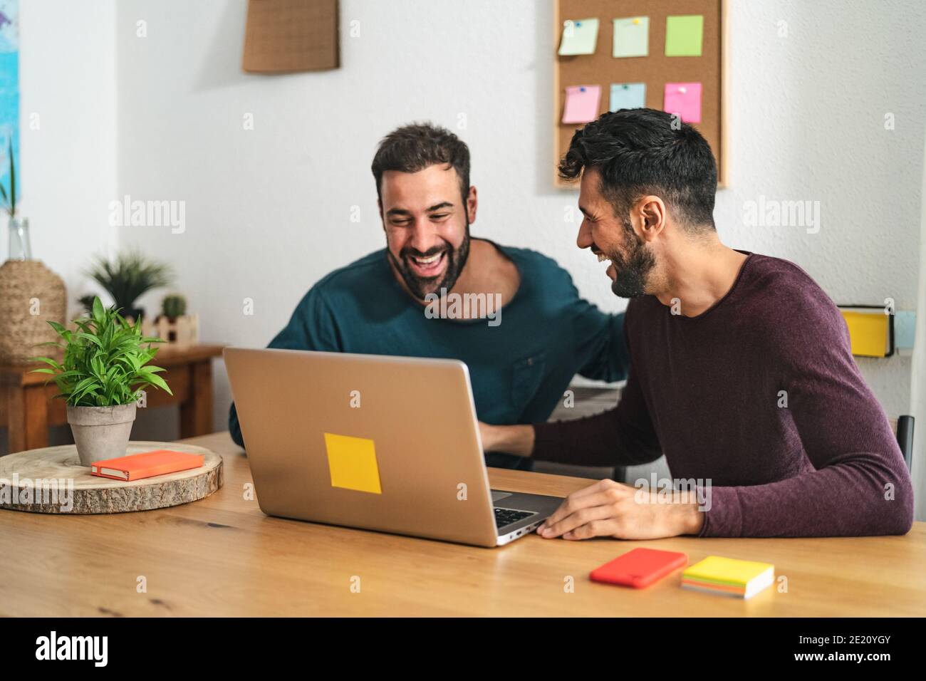 Gay Männer paar mit Laptop im Wohnzimmer zu Hause - homosexuelle Liebe und Geschlechtergleichstellung in Beziehungskonzept Stockfoto