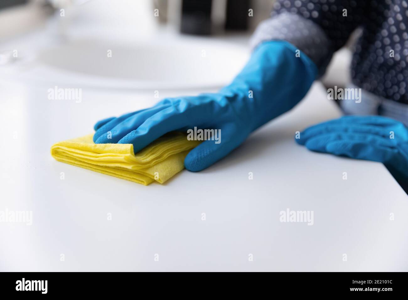 Nahaufnahme der Frau in Handschuhen reinigen Küchenablagen Stockfoto