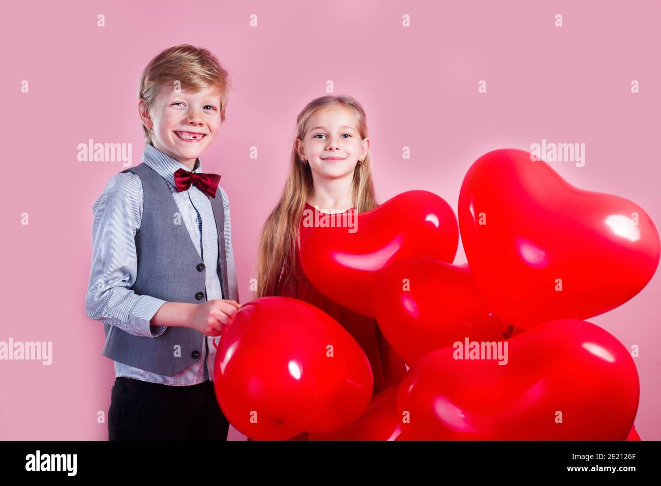 Valentinstag Kinder Mit Roten Herzballons Auf Einem Rosa Hintergrund Stockfotografie Alamy