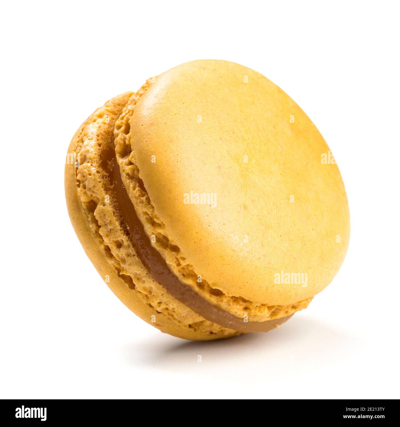 Macaron mit Zitronengeschmack auf weißem Hintergrund isoliert. Nahaufnahme des traditionellen französischen Mandelgebäcks. Stockfoto