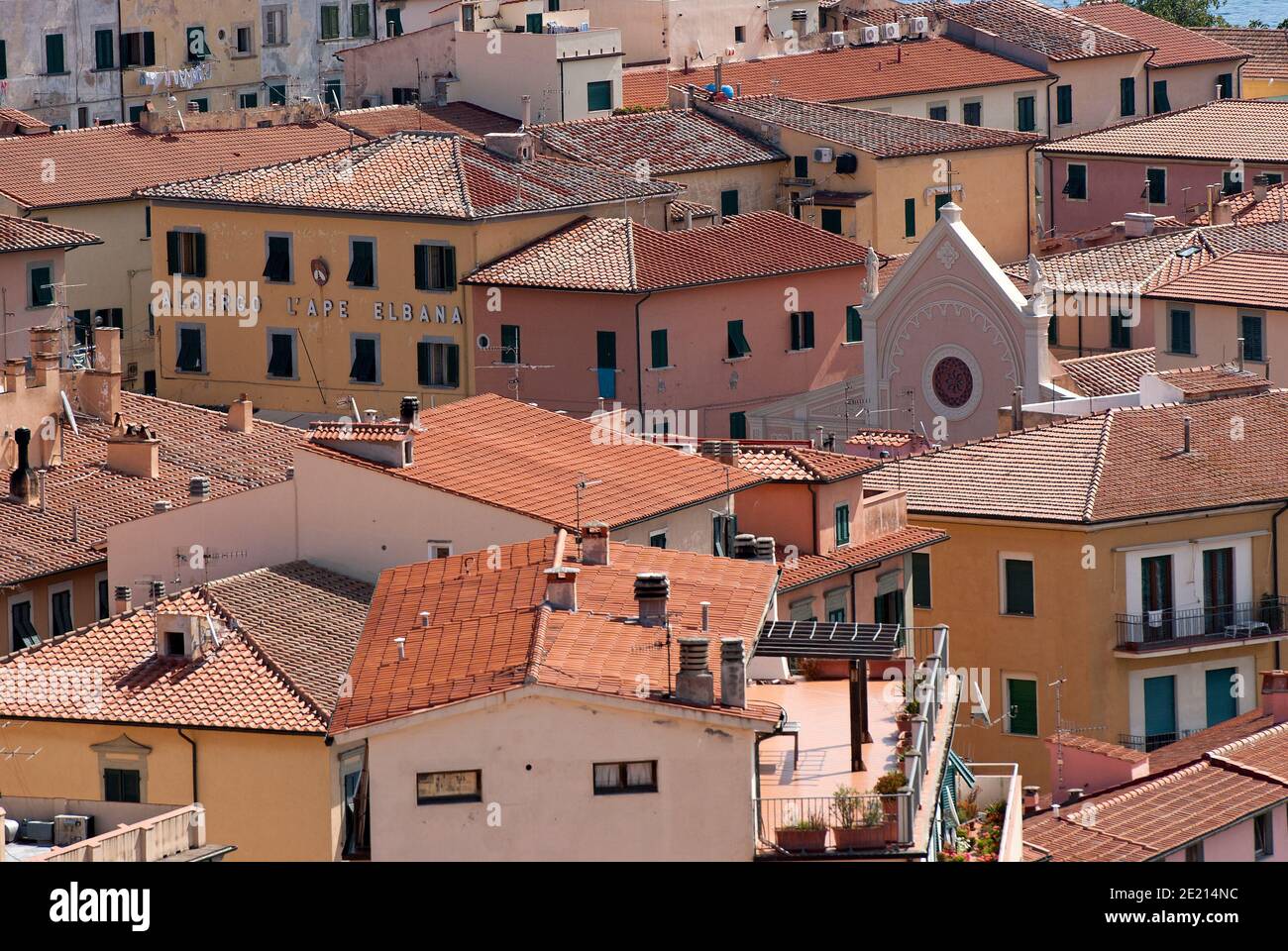 Portoferraio Dorf mit der Spitze der Geburt der Jungfrau Maria Kirche, die sich unter den Häusern, Elba Island, Toskana, Italien Stockfoto