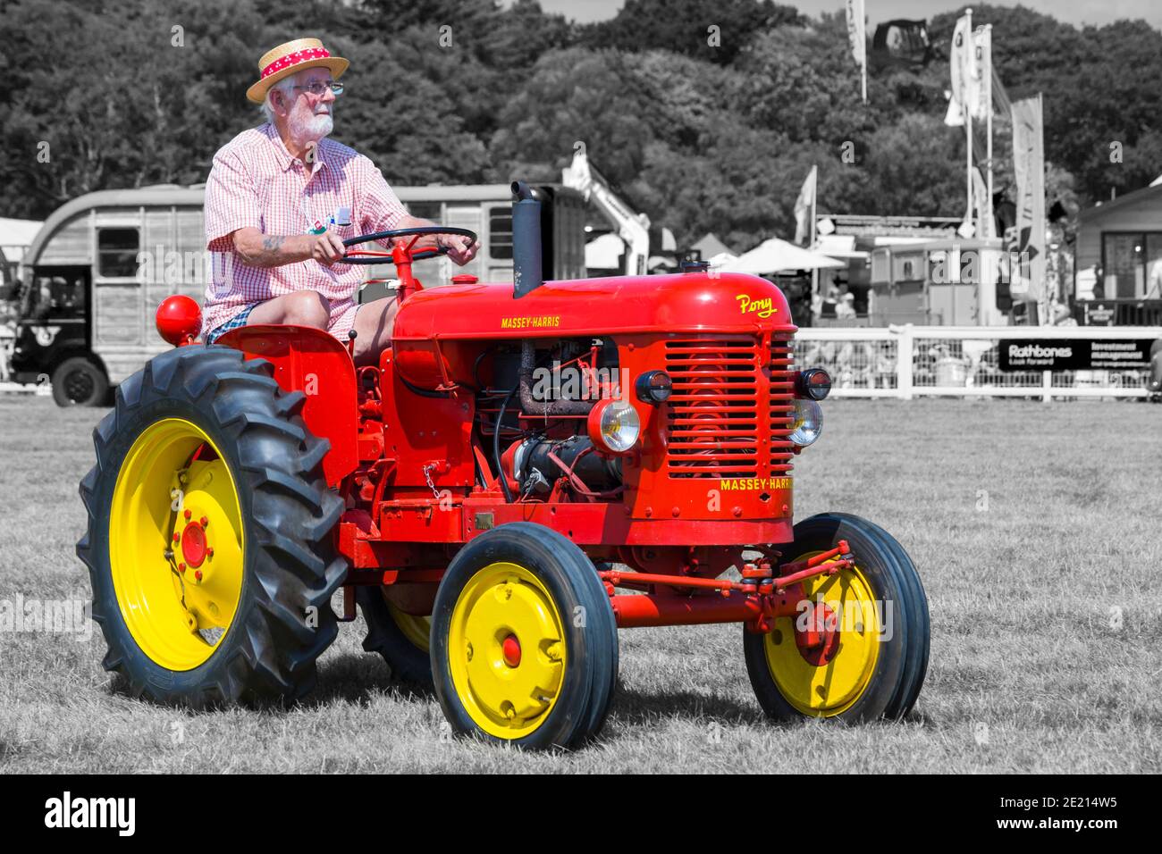 Mann fährt Traktor, Mann fährt in roten Massey-Harris Pony Traktor auf New Forest & Hampshire County Show, Brockenhurst, Hampshire, Großbritannien im Juli Stockfoto