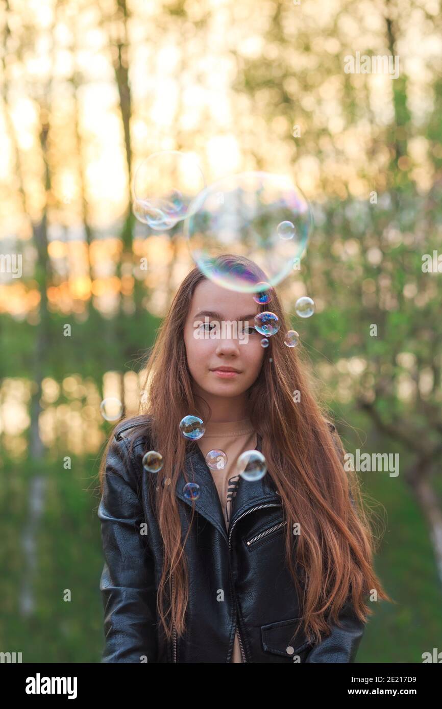 Cute teen Mädchen Blasen Seife Blasen auf dem Feld am Frühlingstag. Stockfoto