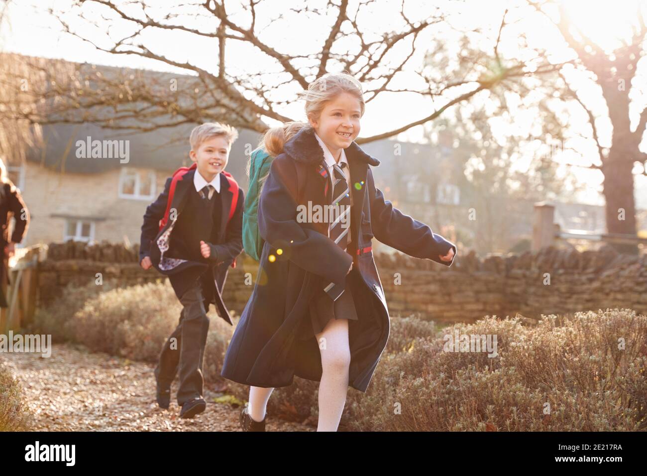 Kinder Tragen Schuluniform Rückkehr Nach Hause Aus Der Schule Läuft Unten Pfad Stockfoto
