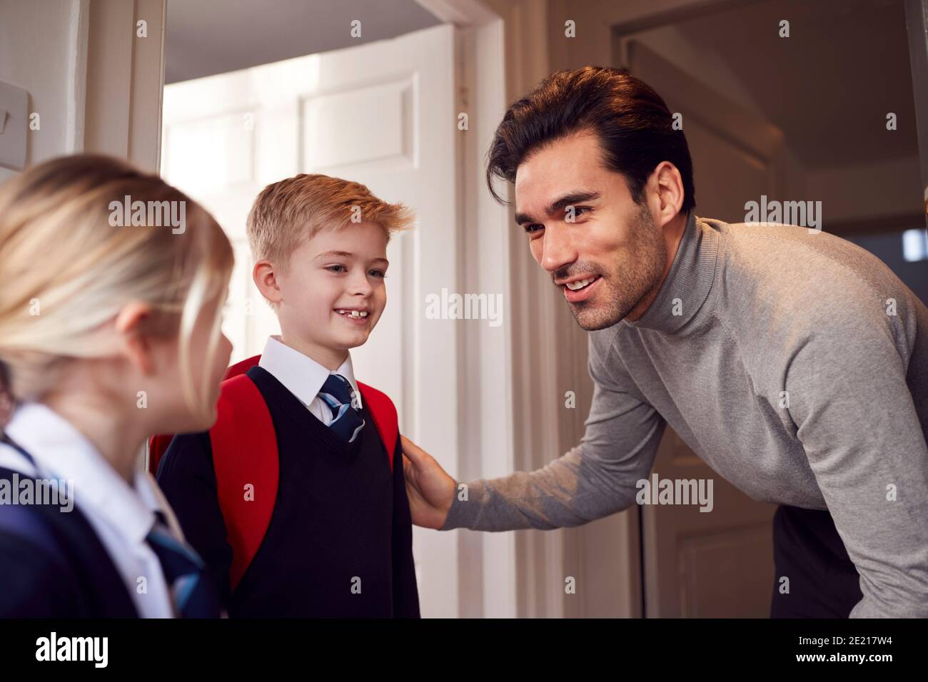 Vater Und Kinder Machen Sich Bereit, Das Haus Zur Schule Zu Verlassen Am Morgen Bei Der Tür Stehen Stockfoto