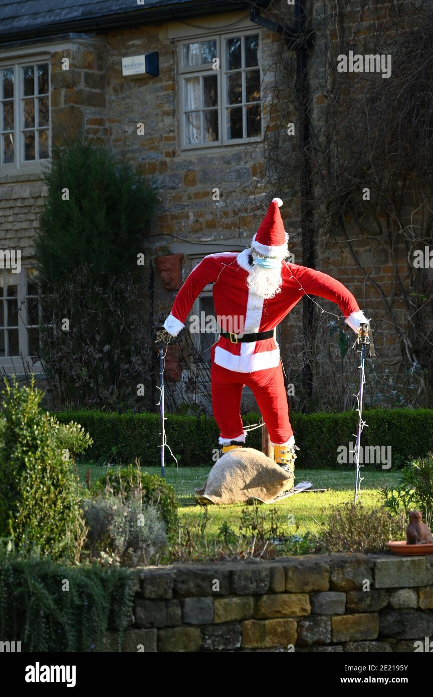 Hausgemachter Weihnachtsmann auf Skiern, eine lustige Dekoration in einem Garten im nördlichen Oxfordshire Dorf Hook Norton während der Weihnachtszeit Stockfoto