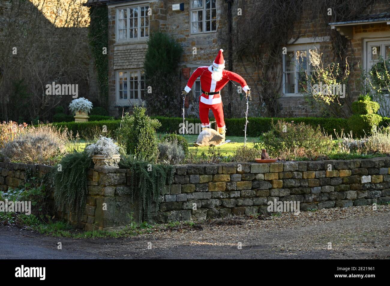 Hausgemachter Weihnachtsmann auf Skiern, eine lustige Dekoration in einem Garten im nördlichen Oxfordshire Dorf Hook Norton während der Weihnachtszeit Stockfoto