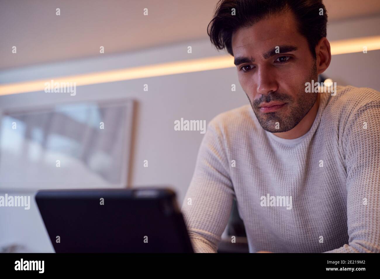 Evening Shot Von Mann In Der Küche Arbeiten Oder Studieren Aus Mit Dem Digitalen Tablet Zu Hause Stockfoto