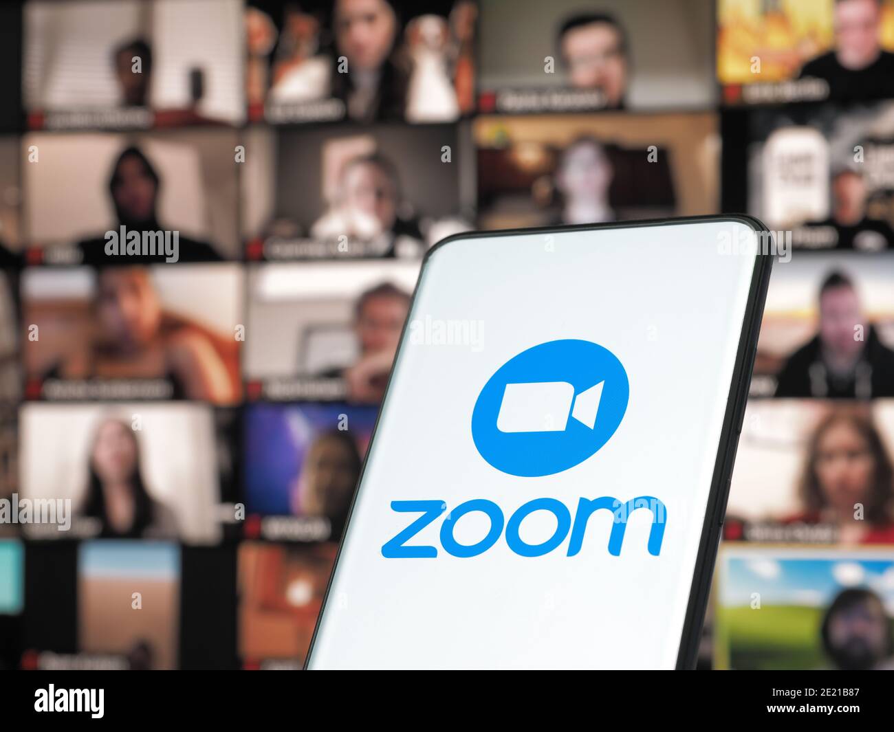 11. Januar 202 - Bukarest, Rumänien: Smartphone startet Zoom Cloud Meetings App mit Meeting auf einem Hintergrundmonitor Stockfoto