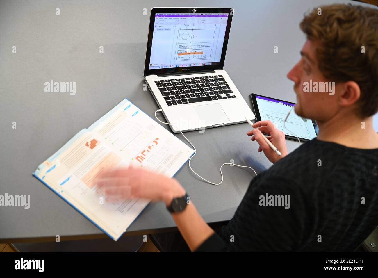 Ravensburg, Deutschland. Januar 2021. KORRIGIERT DEN NAMEN IM TITEL - Carlos Marschall, Mathe- und Spanischlehrer an der Spohnschule, unterrichtet auf einem Laptop in der Lehrerlounge. Für Fernunterricht verwendet er sowohl Laptop als auch iPad. Quelle: Felix Kästle/dpa/Alamy Live News Stockfoto