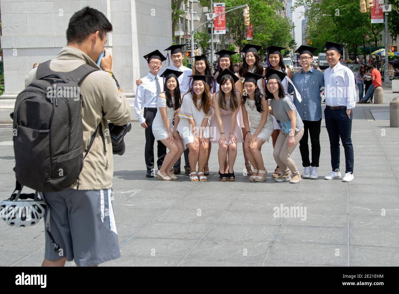 Asiatische NYU-Absolventen mit Abschlusskappen posieren für ein Gruppenfoto im Washington Square Park in New York City.2016, Stockfoto