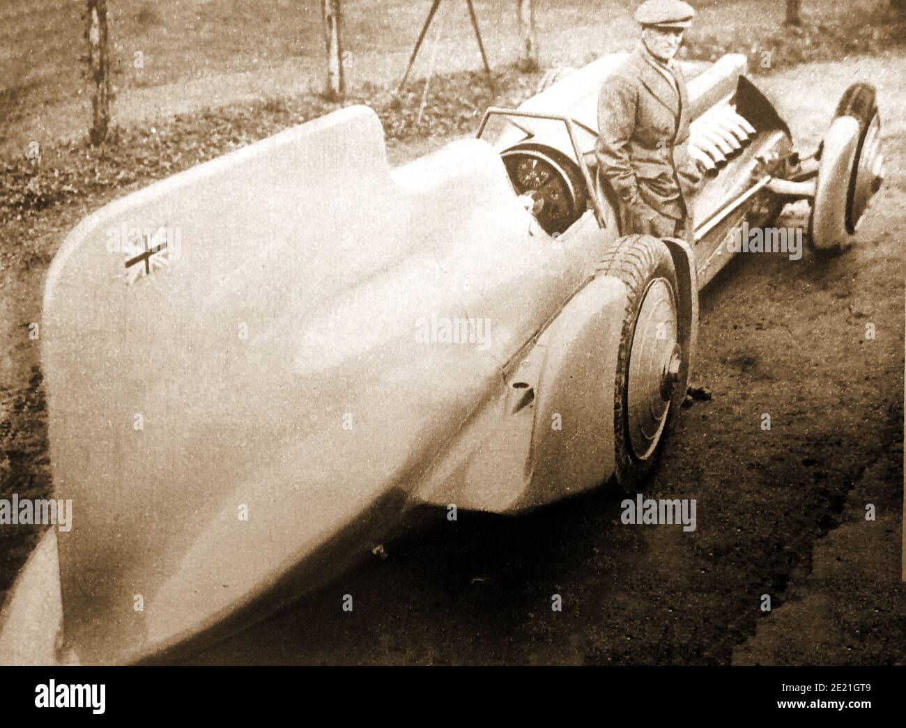 1933 Pressefoto eines informell gekleideten Sir Donald Campbell und seines Rekordwagens Bluebird. Stockfoto