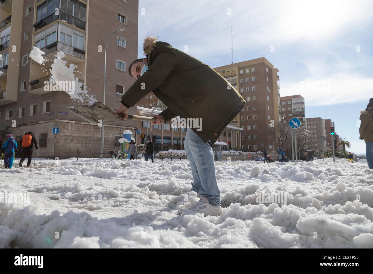 Madrid, Spanien - 10. Januar 2021: Bürger und Nachbarn von Madrid, die an einem verschneiten Tag zusammenarbeiten und den Schnee von den Straßen und Autobahnen säubern, Stockfoto