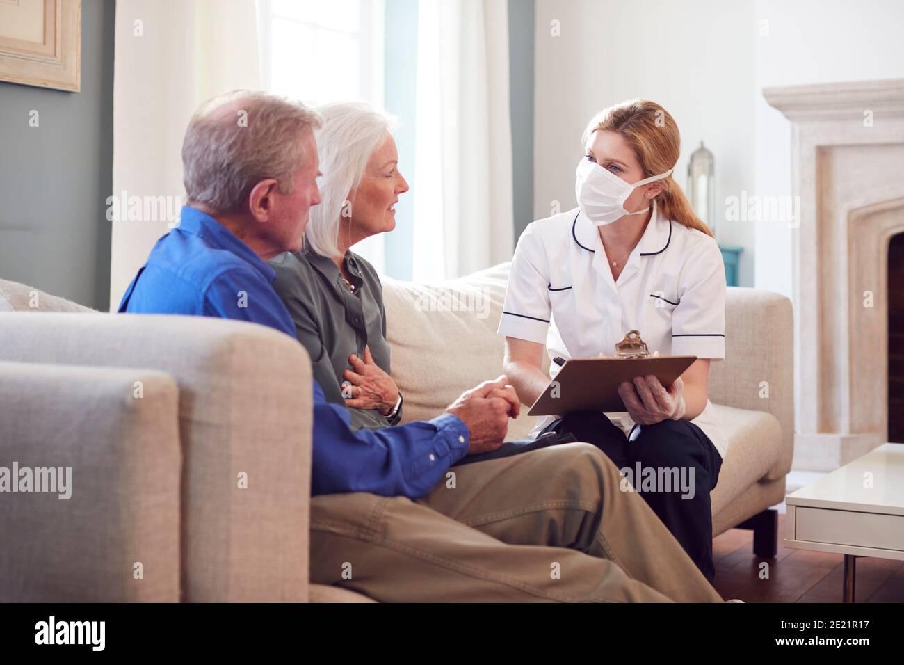 Weibliche Arzt Mit Maske Macht Nach Hause Besuch Zu Älteren Paar Zur Medizinischen Überprüfung Während Der Covid-19-Sperre Stockfoto