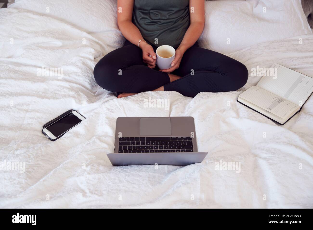 Nahaufnahme Einer Geschäftsfrau Auf Dem Bett Mit Laptop Und Tagebuch Von Zu Hause Aus Arbeiten Stockfoto