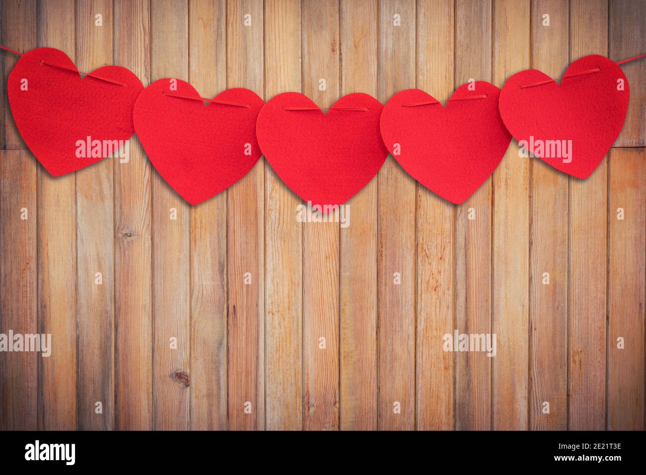 Rotes Herz hängt auf Holz Hintergrund und Textur vertikal. Stockfoto