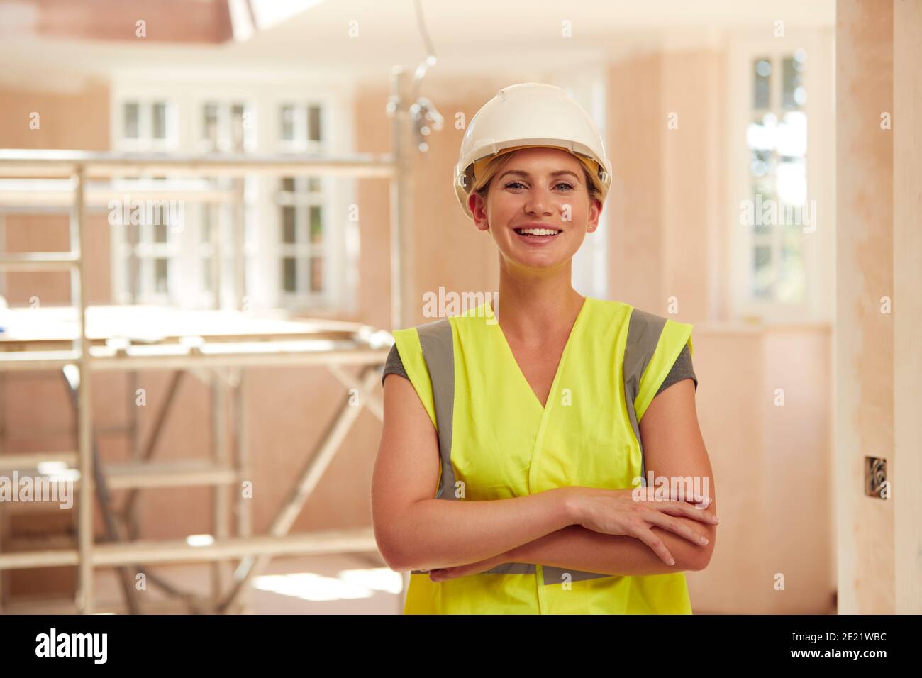 Portrait Von Lächelnden Weiblichen Baumeister Trägt Harten Hut Arbeiten In Neue Build-Eigenschaft Stockfoto