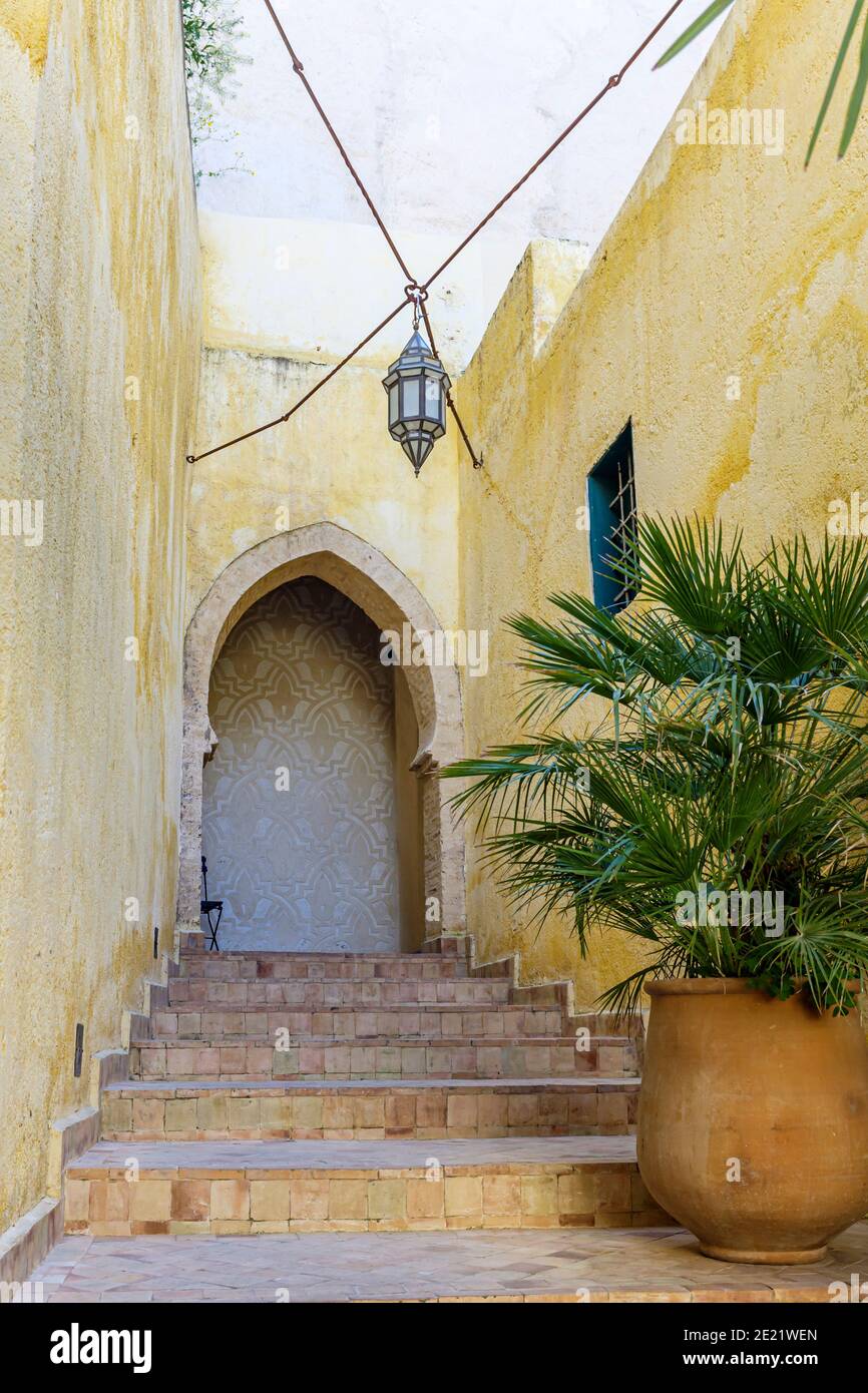 Dekorativer Eingang mit gewölbter Tür, Stufen und Laterne hängen über, in Fes, Marokko Stockfoto